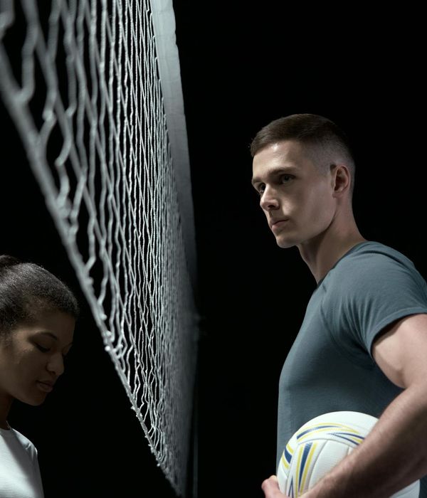 Athletic man performing functional strength exercise in dark studio environment