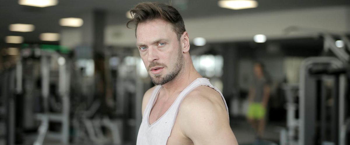 Focused man meditating before intense physical activity in a modern gym